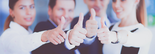 A happy business team showing thumbs up