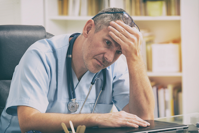 Overworked doctor sitting at desk