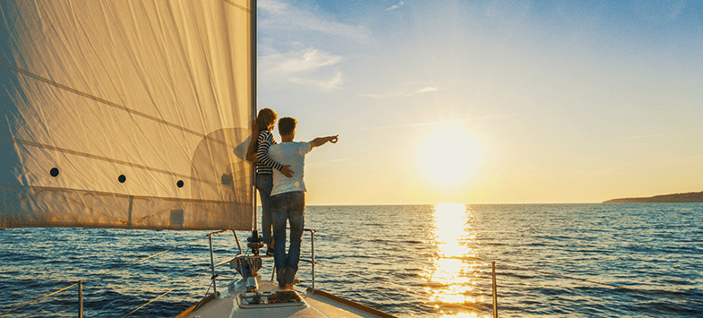 Retired couple sailing at sunset