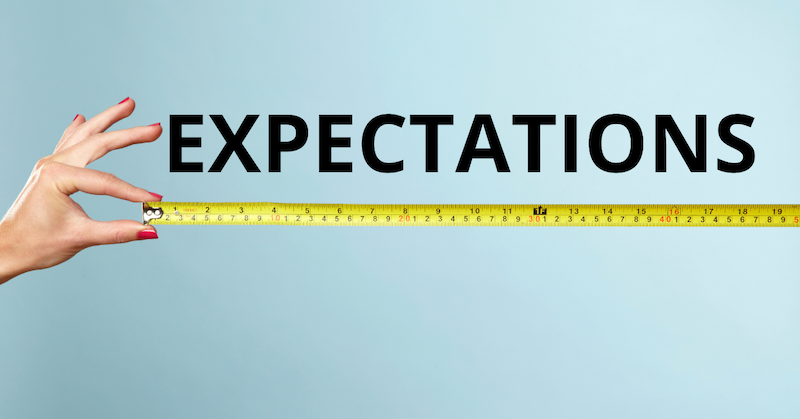 Hand pulling out a measuring tape with the word Expectations above it